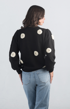 Introducing the Be Different Sweater, a cozy black sweater adorned with white flowers, perfect for adding a touch of charm to your wardrobe. With its soft material, long sleeves, and crew neckline, this sweater offers both comfort and style, making it ideal for any casual outing.

Fabric: 52% Acrylic, 28% Nylon, 20% Polyester

Size Guide: Fits True To Size, Model is Wearing a Size S

Available at our boutiques in Chicago, Lake Geneva, and Milwaukee. (Item availability may vary by location.)