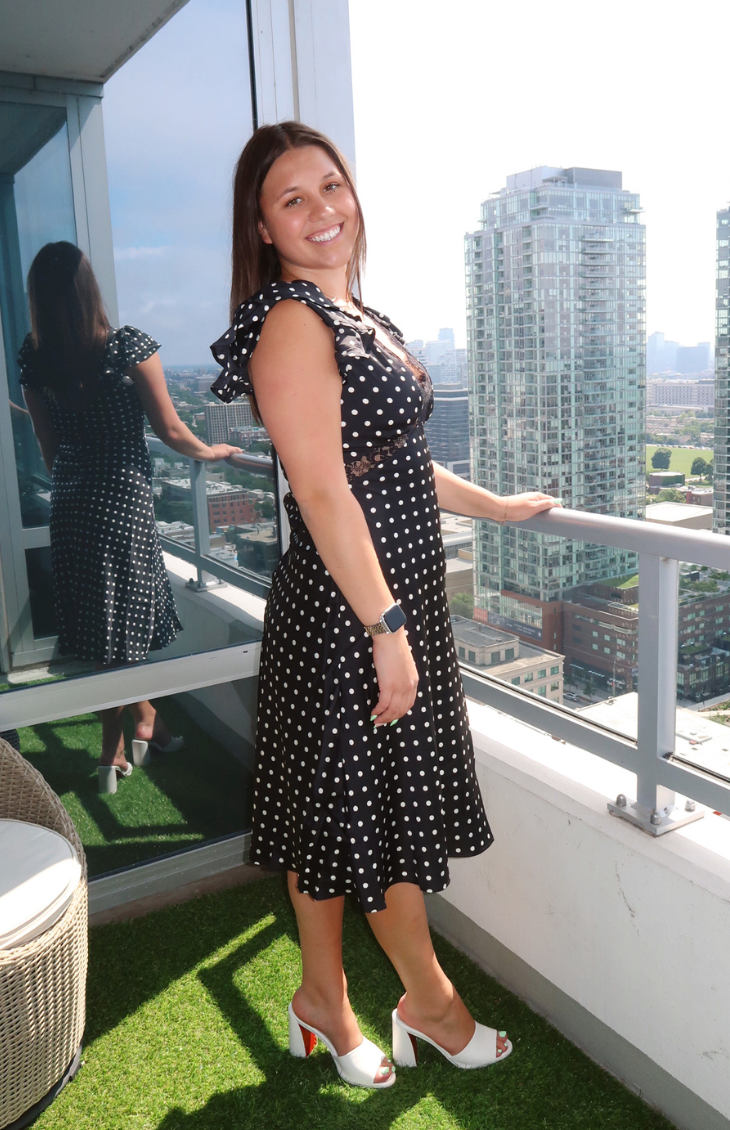 Black midi dress with white polka dots, lace trim, and ruffled sleeves from our boutique in Chicago, Lake Geneva, and Milwaukee. Perfect for an elegant and classic look.