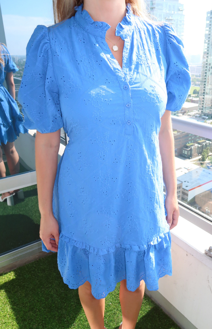 Charming blue eyelet dress with puff sleeves and a ruffled hem, perfect for a cute and casual look from our boutique in Chicago, Lake Geneva, and Milwaukee.