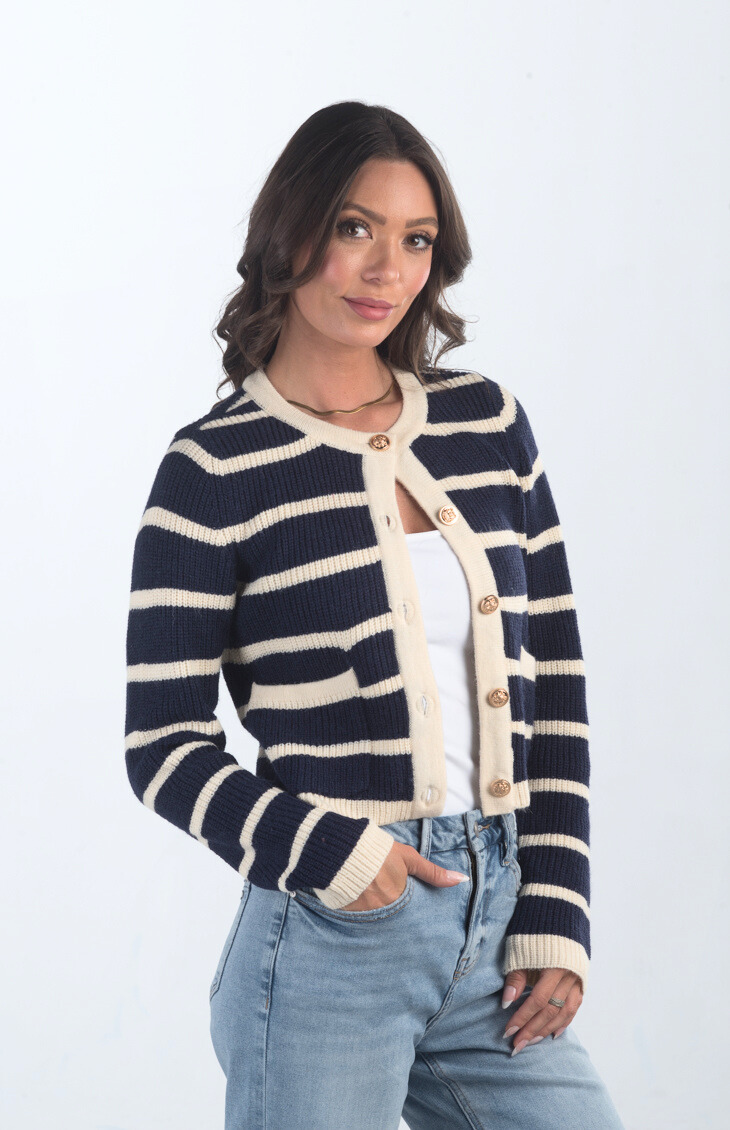 Introducing the Kassidy Striped Cropped Cardigan, a navy and cream striped cardigan that adds a touch of elegance to your wardrobe. This chic cardigan features gold button detailing and a cropped fit, making it perfect for layering or wearing on its own for a polished look.

Fabric: 62% Acrylic, 38% Nylon

Size Guide: Fits True To Size, Model is Wearing a Size S

Available at our boutiques in Chicago, Lake Geneva, and Milwaukee. (Item availability may vary by location.)