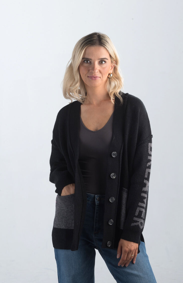 Introducing the Vital Moment Cardigan, a chic black and gray cardigan featuring unique "Dreamer" text on the sleeves. With front pockets and a button-up design, this cardigan combines comfort and style, making it a versatile addition to your wardrobe.

Fabric: 40% Acrylic, 30% Polyester, 30% PBT

Size Guide: Fits True To Size, Model is Wearing a Size S

Available at our boutiques in Chicago, Lake Geneva, and Milwaukee. (Item availability may vary by location.)