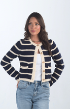 Introducing the Kassidy Striped Cropped Cardigan, a navy and cream striped cardigan that adds a touch of elegance to your wardrobe. This chic cardigan features gold button detailing and a cropped fit, making it perfect for layering or wearing on its own for a polished look.

Fabric: 62% Acrylic, 38% Nylon

Size Guide: Fits True To Size, Model is Wearing a Size S

Available at our boutiques in Chicago, Lake Geneva, and Milwaukee. (Item availability may vary by location.)