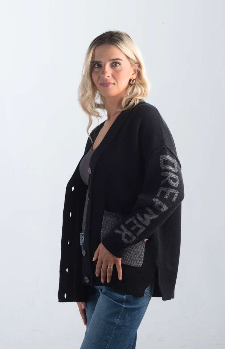 Introducing the Vital Moment Cardigan, a chic black and gray cardigan featuring unique "Dreamer" text on the sleeves. With front pockets and a button-up design, this cardigan combines comfort and style, making it a versatile addition to your wardrobe.

Fabric: 40% Acrylic, 30% Polyester, 30% PBT

Size Guide: Fits True To Size, Model is Wearing a Size S

Available at our boutiques in Chicago, Lake Geneva, and Milwaukee. (Item availability may vary by location.)