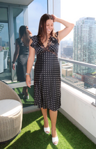 Black midi dress with white polka dots, lace trim, and ruffled sleeves from our boutique in Chicago, Lake Geneva, and Milwaukee. Perfect for an elegant and classic look.