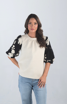 Introducing the Together at Last Top, a beautifully textured ivory top that effortlessly blends elegance with style. Featuring black and white floral designs on the puffy sleeves, this top adds a sophisticated touch to any outfit, making it perfect for both casual and special occasions.

Fabric: Self: 100% Polyester; Lining: 100% Cotton

Size Guide: Fits True To Size, Model is Wearing a Size S

Available at our boutiques in Chicago, Lake Geneva, and Milwaukee. (Item availability may vary by location.)