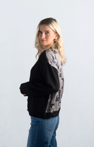 Introducing the It Takes Passion Cardigan, a stylish black button-down cardigan with a twist. The back features a silky material with a beautiful print design, adding an element of surprise and elegance to this cozy piece. Perfect for adding a unique touch to your outfit.

Fabric: 54% Polyester, 20% Acrylic, 20% Nylon, 6% Wool

Size Guide: Fits True To Size, Model is Wearing a Size S

Available at our boutiques in Chicago, Lake Geneva, and Milwaukee. (Item availability may vary by location.)