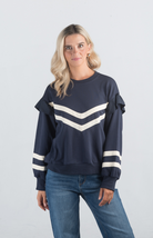 Introducing the Darlene Top, a chic navy sweater featuring white asymmetrical stripes and a delicate ruffle detail on the long sleeves. This unique design adds a touch of elegance and flair to your wardrobe, making it perfect for both casual and sophisticated looks.

Fabric: 85% Cotton, 15% Polyester

Size Guide: Fits True To Size, Model is Wearing a Size S

Available at our boutiques in Chicago, Lake Geneva, and Milwaukee. (Item availability may vary by location.)