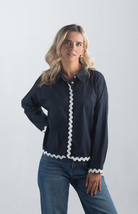 Introducing the Polly Blouse, a stylish navy blouse featuring playful white squiggly stripes. This button-down, collared blouse with long sleeves offers a timeless look, perfect for both casual and professional settings.

Fabric: 100% Cotton

Size Guide: Fits True To Size, Model is Wearing a Size S

Available at our boutiques in Chicago, Lake Geneva, and Milwaukee. (Item availability may vary by location.)