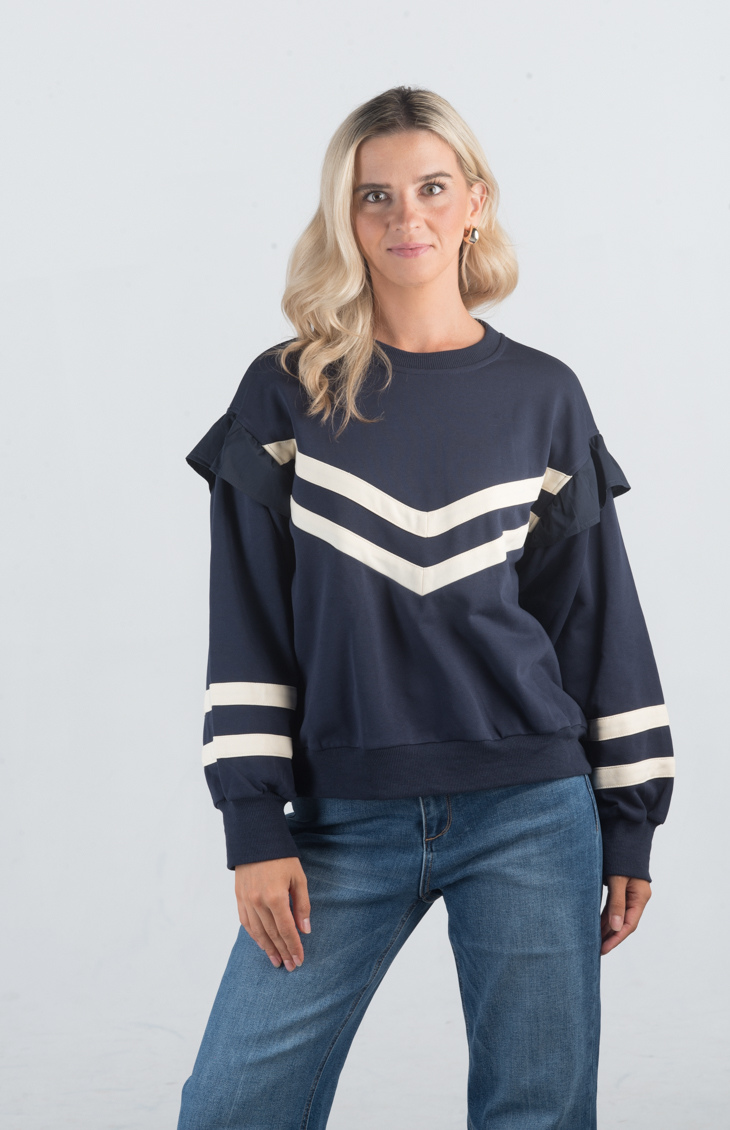 Introducing the Darlene Top, a chic navy sweater featuring white asymmetrical stripes and a delicate ruffle detail on the long sleeves. This unique design adds a touch of elegance and flair to your wardrobe, making it perfect for both casual and sophisticated looks.

Fabric: 85% Cotton, 15% Polyester

Size Guide: Fits True To Size, Model is Wearing a Size S

Available at our boutiques in Chicago, Lake Geneva, and Milwaukee. (Item availability may vary by location.)