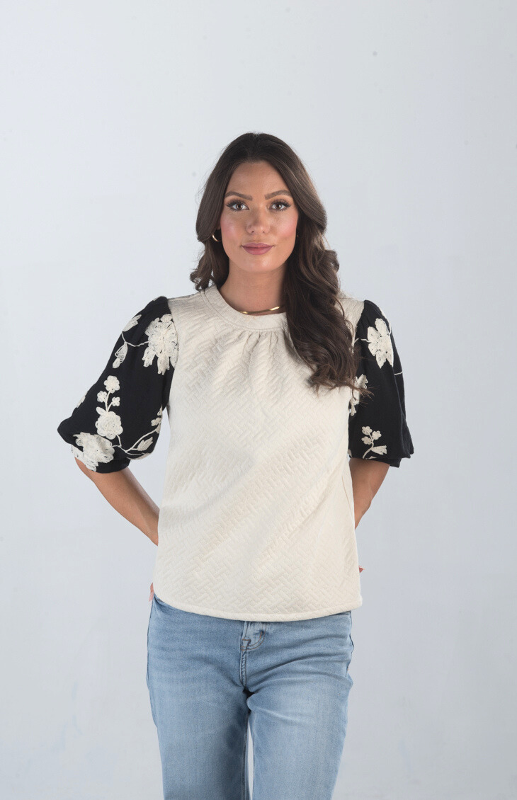 Introducing the Together at Last Top, a beautifully textured ivory top that effortlessly blends elegance with style. Featuring black and white floral designs on the puffy sleeves, this top adds a sophisticated touch to any outfit, making it perfect for both casual and special occasions.

Fabric: Self: 100% Polyester; Lining: 100% Cotton

Size Guide: Fits True To Size, Model is Wearing a Size S

Available at our boutiques in Chicago, Lake Geneva, and Milwaukee. (Item availability may vary by location.)