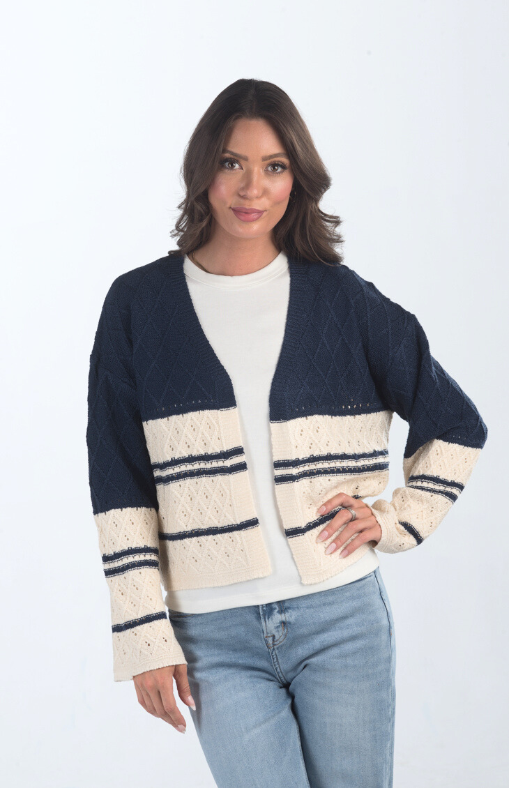 Introducing the Different Views Sweater, a luxurious midnight blue and cream knit cardigan that offers both comfort and style. Made from soft materials, this sweater is perfect for layering, providing warmth and elegance for any outfit.

Fabric: 95% Acrylic, 5% Nylon

Size Guide: Fits True To Size, Model is Wearing a Size S

Available at our boutiques in Chicago, Lake Geneva, and Milwaukee. (Item availability may vary by location.)