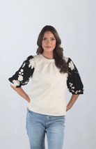 Introducing the Together at Last Top, a beautifully textured ivory top that effortlessly blends elegance with style. Featuring black and white floral designs on the puffy sleeves, this top adds a sophisticated touch to any outfit, making it perfect for both casual and special occasions.

Fabric: Self: 100% Polyester; Lining: 100% Cotton

Size Guide: Fits True To Size, Model is Wearing a Size S

Available at our boutiques in Chicago, Lake Geneva, and Milwaukee. (Item availability may vary by location.)