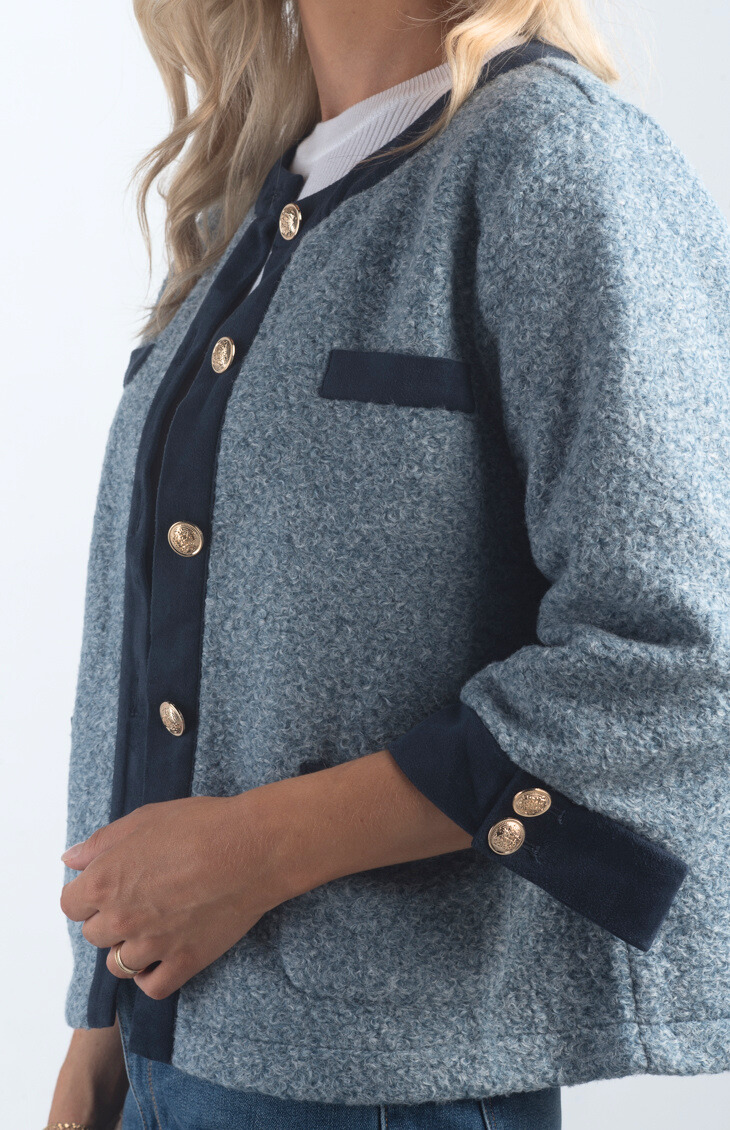 Introducing the A Little Dramatic Cardigan, a chic slate blue light jacket that combines style with subtle drama. Featuring gold button detailing and navy accents on the hem, this cardigan is perfect for adding a sophisticated touch to any outfit.

Fabric: Self: 50% Polyester, 50% Rayon; Contrast: 92% Polyester, 8% Spandex

Size Guide: Fits True To Size, Model is Wearing a Size S

Available at our boutiques in Chicago, Lake Geneva, and Milwaukee. (Item availability may vary by location.)