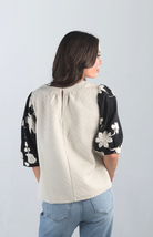 Introducing the Together at Last Top, a beautifully textured ivory top that effortlessly blends elegance with style. Featuring black and white floral designs on the puffy sleeves, this top adds a sophisticated touch to any outfit, making it perfect for both casual and special occasions.

Fabric: Self: 100% Polyester; Lining: 100% Cotton

Size Guide: Fits True To Size, Model is Wearing a Size S

Available at our boutiques in Chicago, Lake Geneva, and Milwaukee. (Item availability may vary by location.)