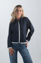 Introducing the Polly Blouse, a stylish navy blouse featuring playful white squiggly stripes. This button-down, collared blouse with long sleeves offers a timeless look, perfect for both casual and professional settings.

Fabric: 100% Cotton

Size Guide: Fits True To Size, Model is Wearing a Size S

Available at our boutiques in Chicago, Lake Geneva, and Milwaukee. (Item availability may vary by location.)