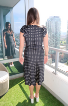 Black midi dress with white polka dots, lace trim, and ruffled sleeves from our boutique in Chicago, Lake Geneva, and Milwaukee. Perfect for an elegant and classic look.